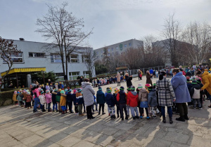 Widok na wszystkich uczestników spotkania i budynek przedszkola