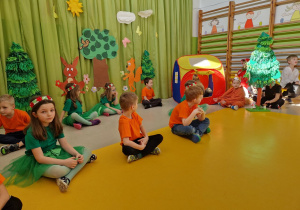 Dzieci - aktorzy siedzący na sali w sadzie skrzyżnym