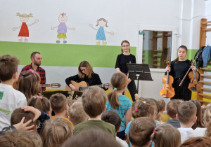 Muzycy ze szkoły muzycznej zadają dzieciom pytania o instrumenty