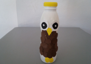 Sowa wykonana przy użyciu plastikowej butelki, kartek w kolorze żółtym i brązowym.