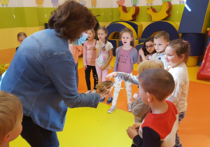 Dzieci z grupy VI dotykają jaszczurkę.