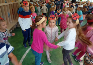 Dzieci z grupy biedronek tańczą w kółeczku.
