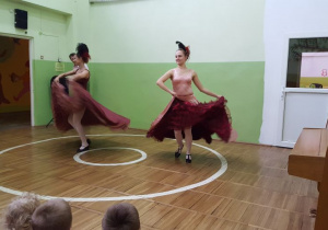Dwie tancerki w bordowych spódnicach podczas tańca