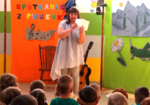 Pani Agatka pokazuje dzieciom śpiewnik.