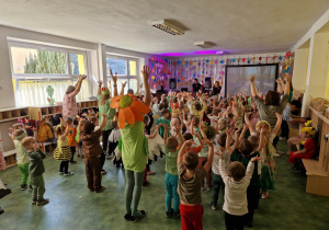 Uczestnicy balu z podniesionymi rękami podczas zabawy