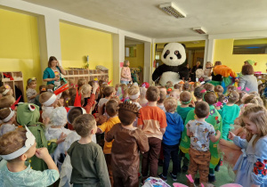Dzieci witające osobę przebraną za maskotkę pandy