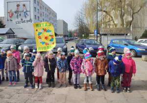 Dzieci z grupy V trzymające baner "Witaj wiosno"