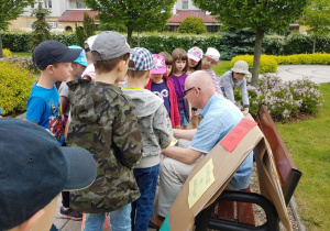 Prezes Spółdzielni Radogoszcz Wschód podczas czytania bajki dzieciom na Placu Słonecznym