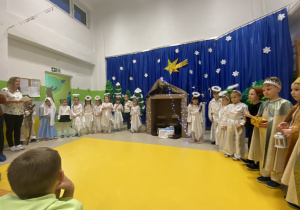 Widok na występujące dzieci i wychowawczynię