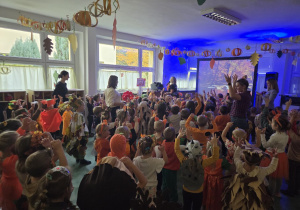 Widok z końca sali na dzieci podczas łapania baniek mydlanych