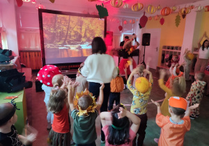 Widok na dzieci i animatorkę prowadzącą zabawę