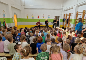 Pan i Panie ze szkoły muzycznej prezentują dzieciom instrumenty na których będą grać