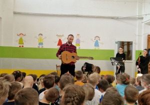 Pan ze szkoły muzycznej prezentuje gitarę