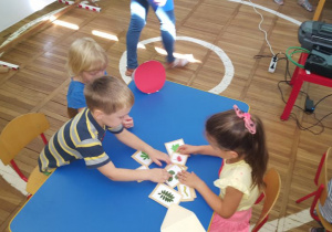 Dzieci łączą obrazki liści z ich owocami.