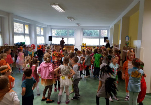 Wszystkie dzieci biorące udział w balu tańczą w rytm muzyki.
