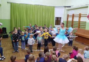 Tancerka uczy chłopców podstawowych kroków baletowych.