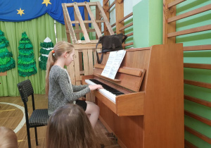 Dziewczynka gra na pianinie.