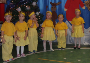Dzieci przebrane za gwiazdeczki stojąc w półkolu śpiewają piosenkę.