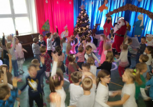 Dzieci tańczą w rytm muzyki ze Świętym Mikołajem.