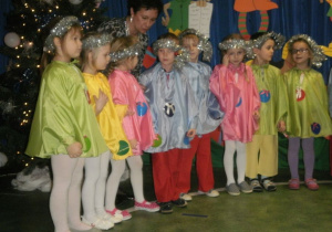 Dzieci przebrane za choinki śpiewają piosenkę świąteczną.