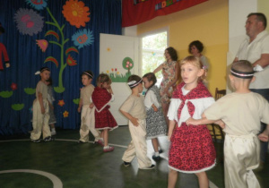 Dzieci przebrane w stroje góralskie prezentują układ taneczny.