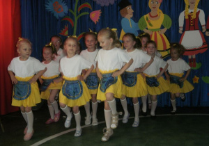 Dziewczynki w strojach ludowych prezentują układ choreograficzny.