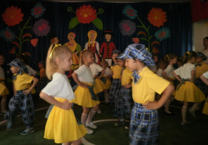 Dzieci w strojach ludowych prezentują układ choreograficzny.