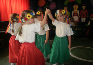 Dziewczynki w strojach góralskich prezentują układ taneczny.