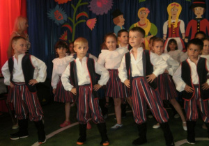 Chłopcy w strojach góralskich prezentują układ taneczny.