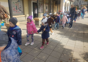 Dzieci idące w korowodzie przez Plac Słoneczny.