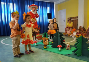 Wybrane pary dzieci biorą udział w zabawie polegającej na zrywaniu jadalnych grzybów.