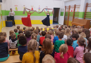 Tancerki prezentują taniec z kolorowymi chustami.