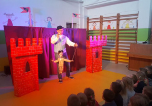 Aktor porusza chłopcem - marionetką.