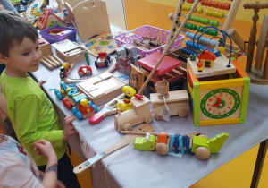 Dzieci z grupy IV zwiedzają wystawę zabawek z drewna.