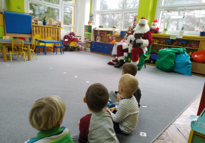 Mikołaj poazkuje księgę życzeń dzieciom z grupy II.