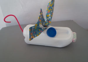 Myszka wykonana przy użyciu butelki po mleku, dwóch niebieskich nakrętek, kolorowej serwetki, drucika kreatywnego.