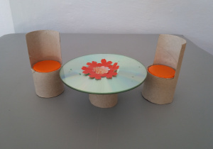 Stół z krzesłami wykonany przy użyciu rolek po papierze, płyty cd i nakrętek od butelek.