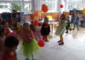 Dzieci z grupy VIII podrzucają czerwonymi balonami.