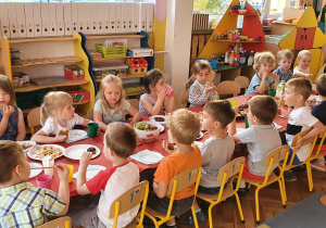 Dzieci przy stole podczas poczęstunku w grupie I