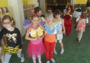 Dzieci pozują do zdjęcia trzymając kolorowe motyle.