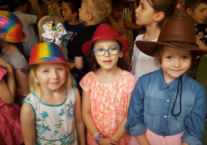 Dziewczynki w kolorowych kapeluszach pozują do zdjęcia.